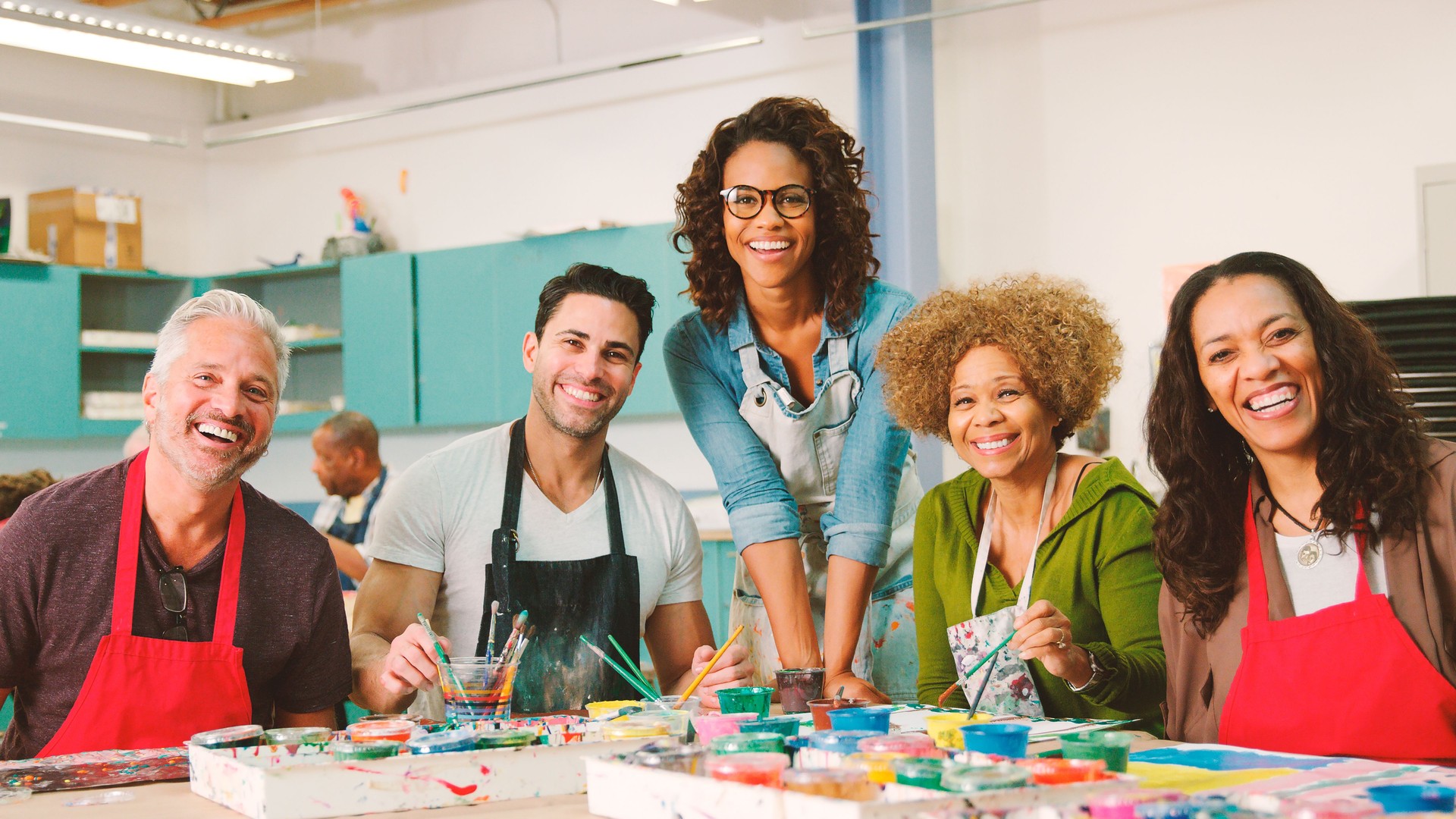 Portrait Of Mature Adults Attending Art Class In Community Centre With Teacher